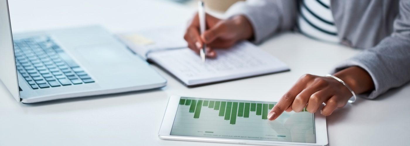 Making money work for her business Shot of an unrecognizable businesswoman using a digital tablet with graphs on it in a modern office